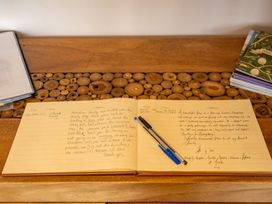 A guestbook and pen on a wooden table at Pendle View in Preston