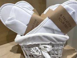 A gift basket with slippers and a tag at Pendle View Preston