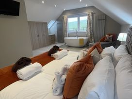 A bedroom with a bathtub and seating area at Pendle View in Preston