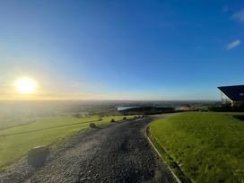 A outdoor landscape with a road leading to a hill and a waterbody at Pendle View Preston