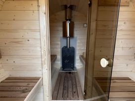 A sauna with wooden walls and benches and a stove at Pendle View Preston