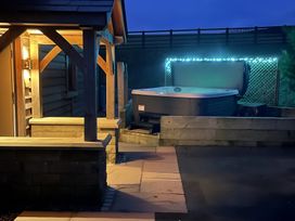 An outdoor area with a hot tub and covered seating at Pendle View in Preston