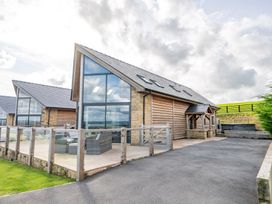 An outdoor view of a wooden building with a patio at Pendle View in Preston