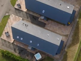 An outdoor area with two buildings and a hot tub at Pendle View Preston