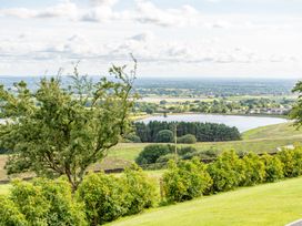 A view of a river and fields with trees at Pendle View Preston