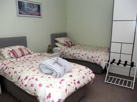 A bedroom with two beds and a storage unit at The Farmhouse in Omagh