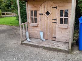 A small wooden shed with boots outside at The Farmhouse in Omagh