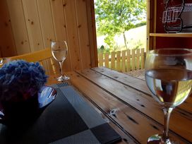 A dining room with a table, glasses, and flowers at Bryn Mawr Cabin in Craven Arms