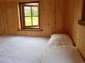 A bedroom with a bed and a window at Bryn Mawr Cabin in Craven Arms