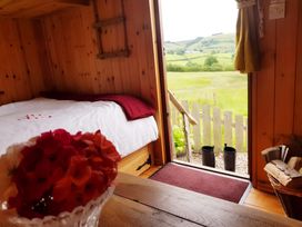 A bedroom with a bed and flowers at Bryn Mawr Cabin in Craven Arms
