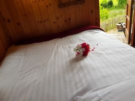 A bed with flowers on the sheets at Bryn Mawr Cabin in Craven Arms