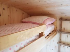 A bunk bed with polka dot bedding at Bryn Mawr Cabin Craven Arms