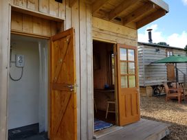 A shower and wooden doors at Bryn Mawr Cabin in Craven Arms