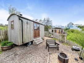 A wooden hut with steps and outdoor seating at Bryn Mawr Cabin, Clun