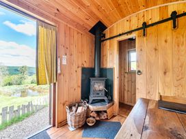 An indoor view featuring a wood stove and wooden walls at Bryn Mawr Cabin in Clun