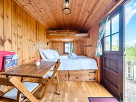 A bedroom with a bed and table at Bryn Mawr Cabin in Clun