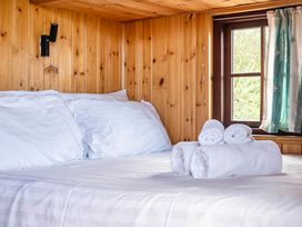 A bedroom with a bed a window and towels at Bryn Mawr Cabin in Clun