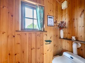 A bathroom featuring a toilet and window at Bryn Mawr Cabin in Clun