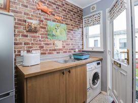 A kitchen with a washing machine and sink at Beechtree Lodge 46 in Denny