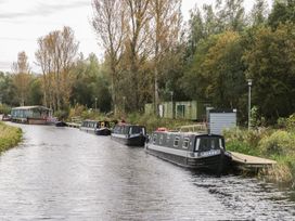 A canal with moored boats and trees at Beechtree Lodge 46 Denny