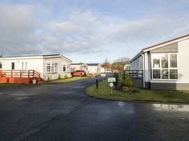 An outdoor area with mobile homes and a car at Beechtree Lodge 46 Denny