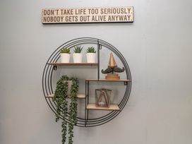 A wall shelf with plants and decorative items at Beechtree Lodge 55 in Denny