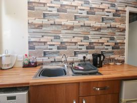 A kitchen with a sink and dish drainer at Beechtree Lodge 55 Denny