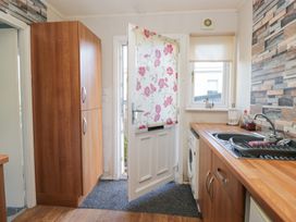 A kitchen with a door and a fridge at Beechtree Lodge 55 Denny