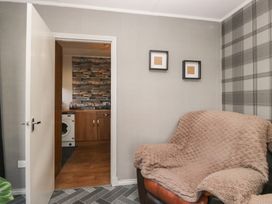 A living room with a sofa and open door to kitchen at Beechtree Lodge 57 Denny