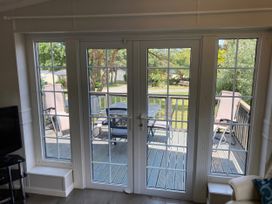 A living room with patio doors viewing a deck at Caravan 38 in Newport