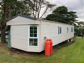 A caravan with gas cylinders and windows at Caravan 38 Newport