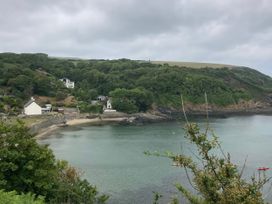 A scenic view of a beach and water surrounded by greenery and houses at Caravan 38 Newport
