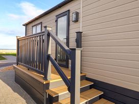Steps leading to a door with a railing at Paws By The Sea in Norwich