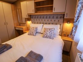 A bedroom with a bed and wardrobe at Paws By The Sea Norwich