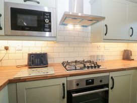 A kitchen with appliances and a wooden countertop at Mables in Wigton