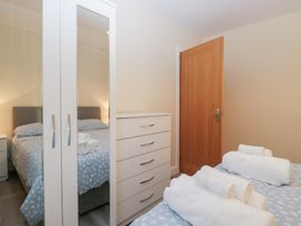 A bedroom with a bed, dresser, wardrobe, and towels at Mables in Wigton