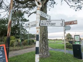 A signpost indicating directions and distances to various locations near a park