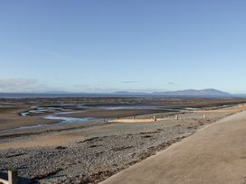 A beach with a river flowing and mountains in the background at Mables in Wigton