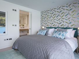 A bedroom with a bed and an adjoining bathroom at Villa 8, Estura in Salcombe