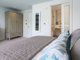 A bedroom with a bed and wardrobe at Villa 8, Estura in Salcombe