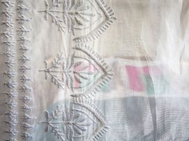 A close-up of embroidered fabric with intricate designs
