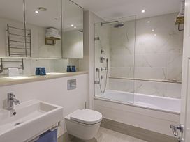 A bathroom with a sink, toilet, bath tub, and shower at Villa 8, Estura Salcombe