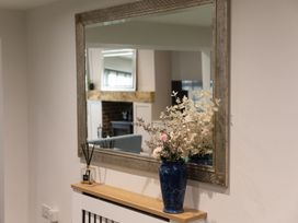 A mirror and vase with flowers on a table in a living room at 6 Front Street
