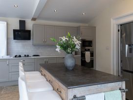 A kitchen with a table, chairs, stove, and a vase of flowers at 6 Front Street