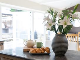A kitchen with a vase of flowers and croissants on a table at 6 Front Street