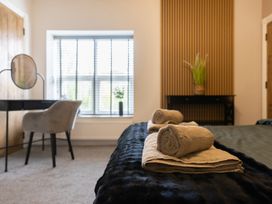 A bedroom with towels on a bed and a desk with a mirror at 6 Front Street 