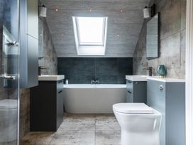A bathroom with a bathtub, sinks and a skylight at 6 Front Street 
