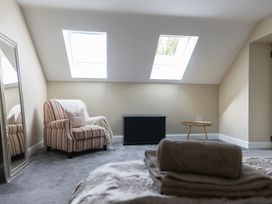 A bedroom with a striped armchair and a mirror at 6 Front Street