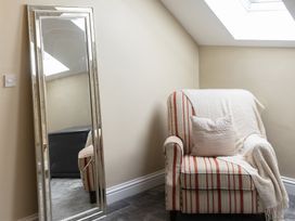 A living room with a striped chair and a mirror at 6 Front Street 