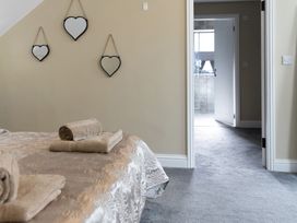 A bedroom with towels on the bed and a doorway leading to another room at 6 Front Street